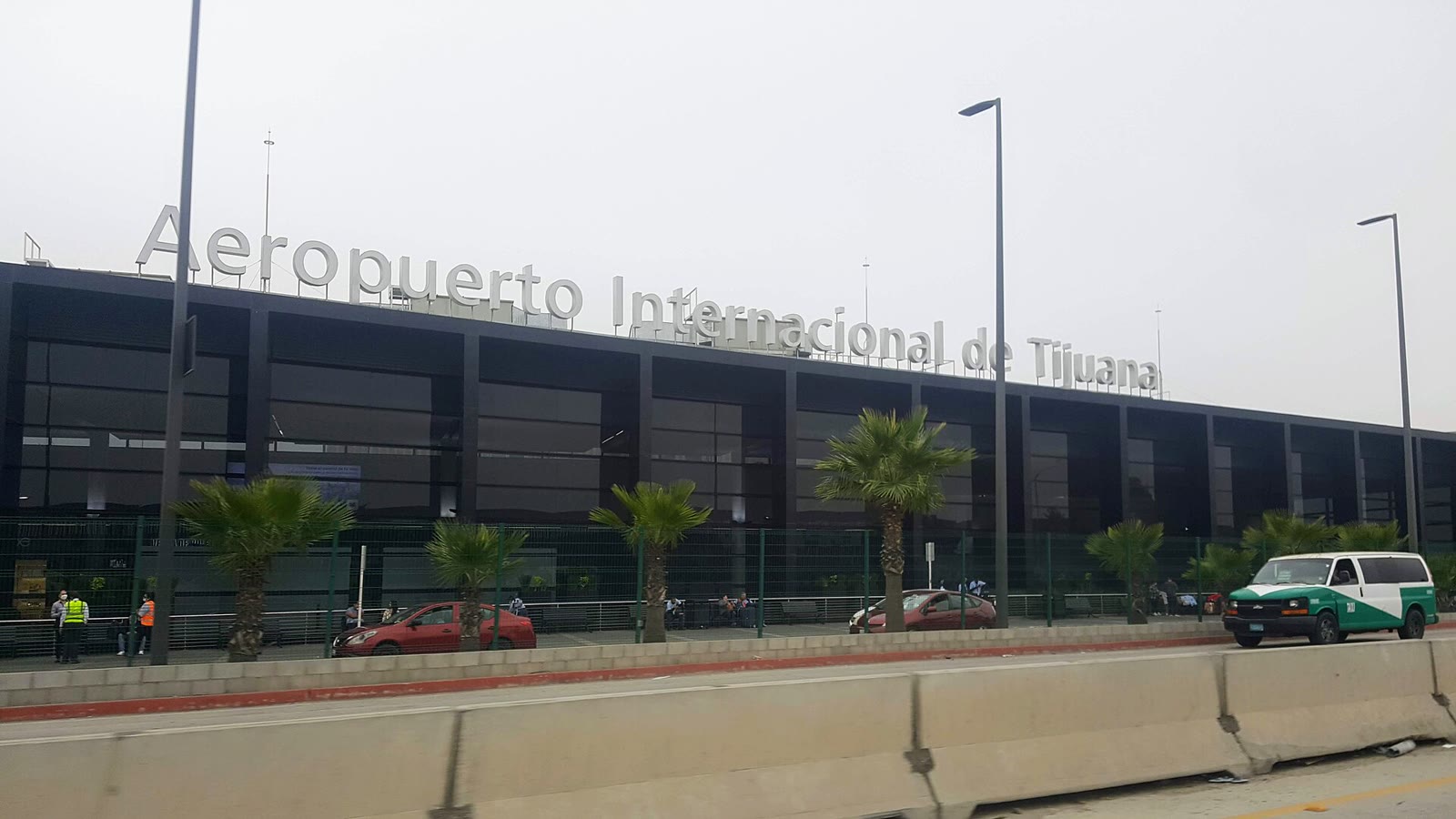 Fachada del Aeropuerto Internacional de Tijuana con su letrero y palmeras delante