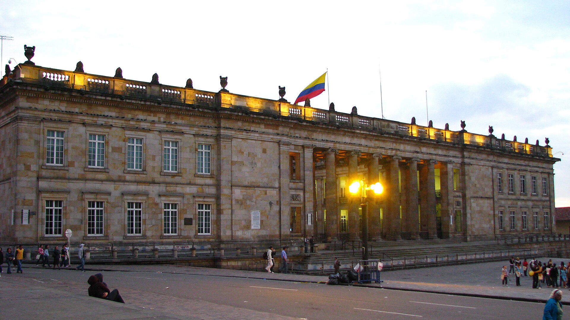 Bogotá's National Capitol at dusk, with its columns lit up and the Colombian flag flying on top