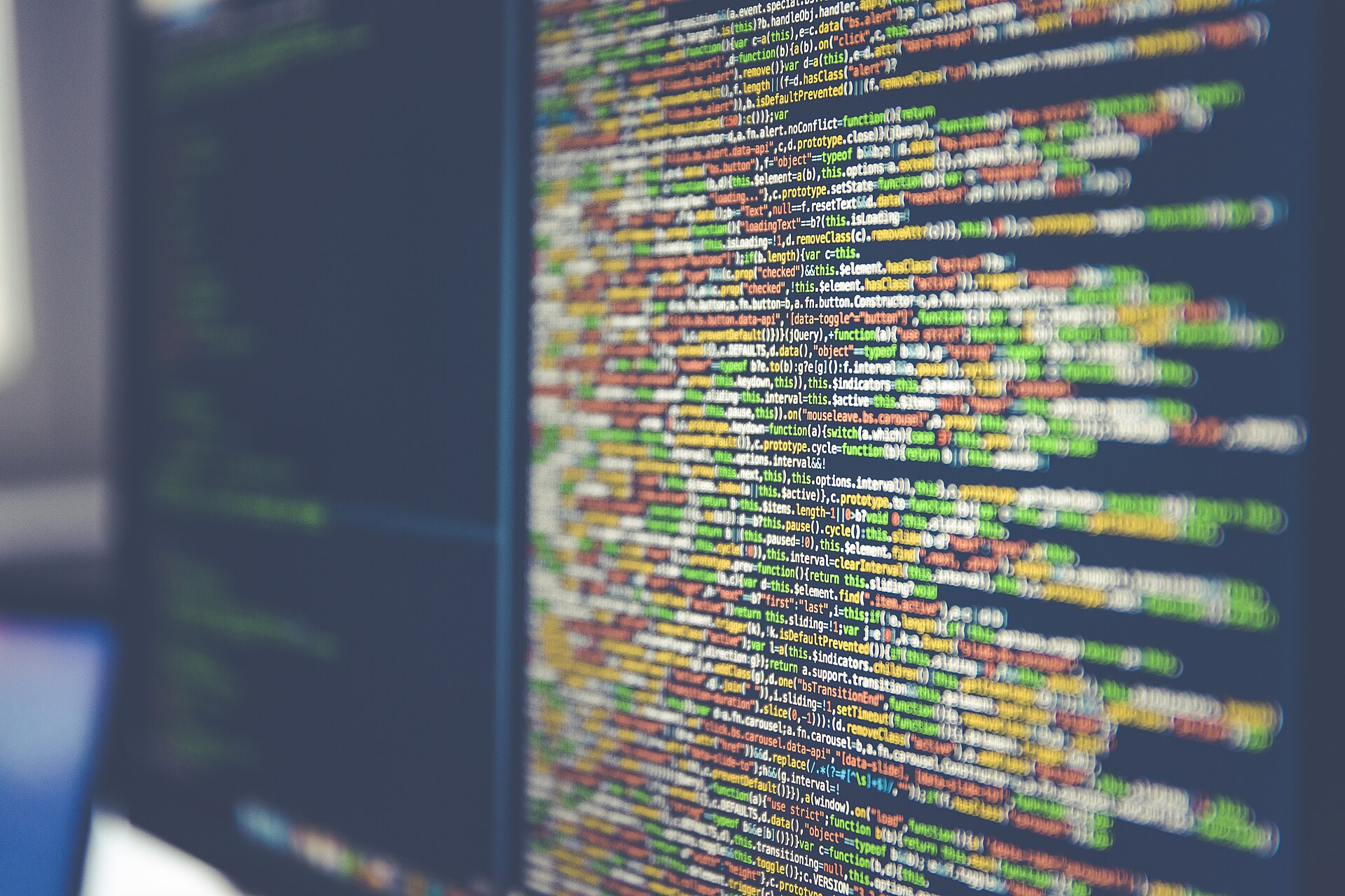 A computer screen full of lines of colorful programming code on a dark background