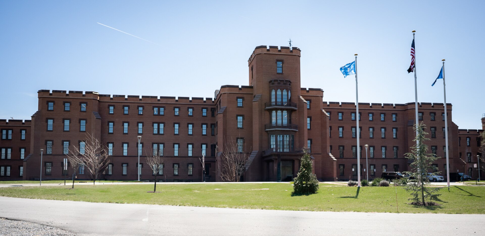 Red brick building with a central tower and three flags on the St. Elizabeths campus in Washington