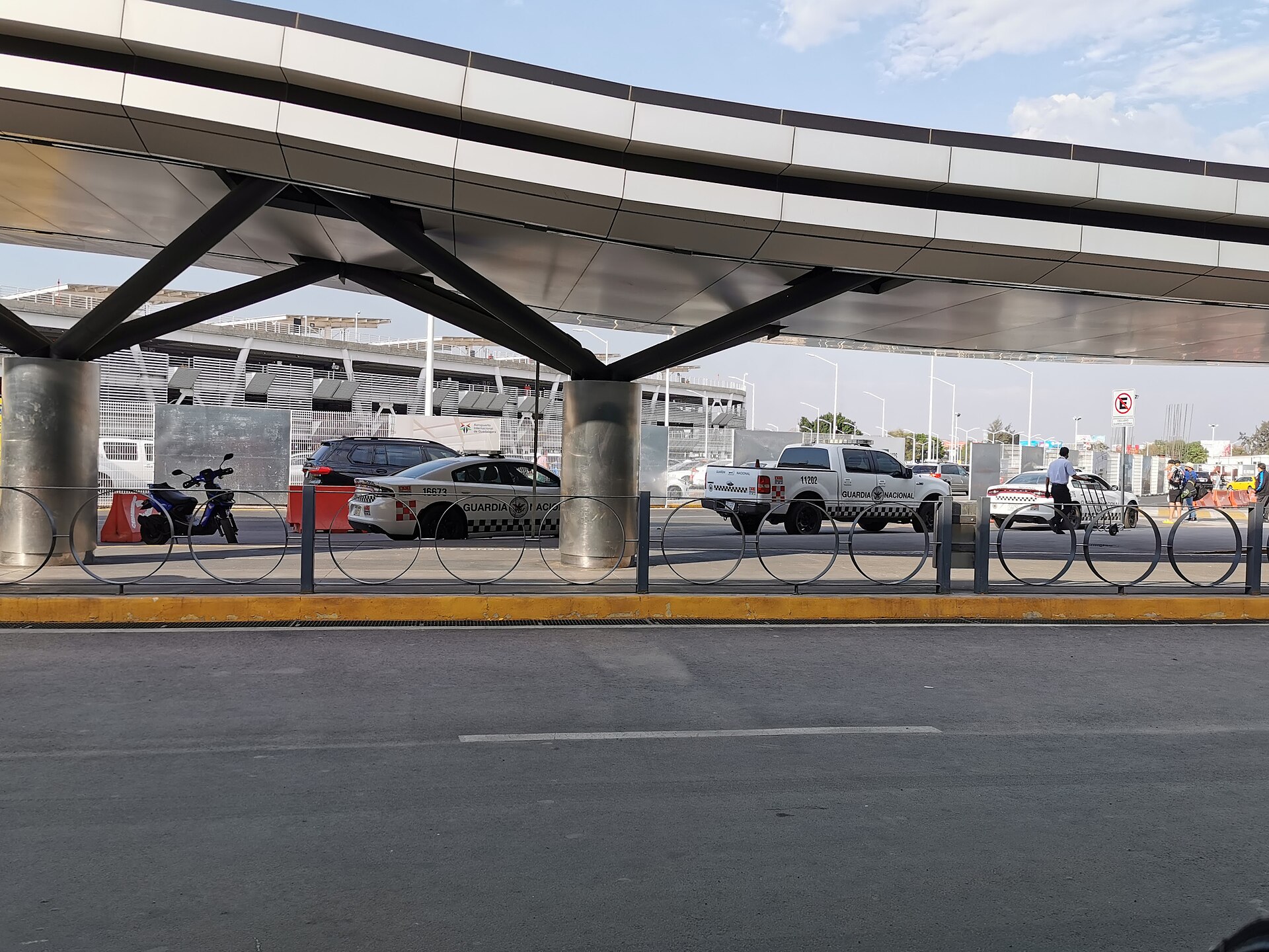 Duas viaturas brancas da Guarda Nacional estacionadas sob uma grande estrutura de metal