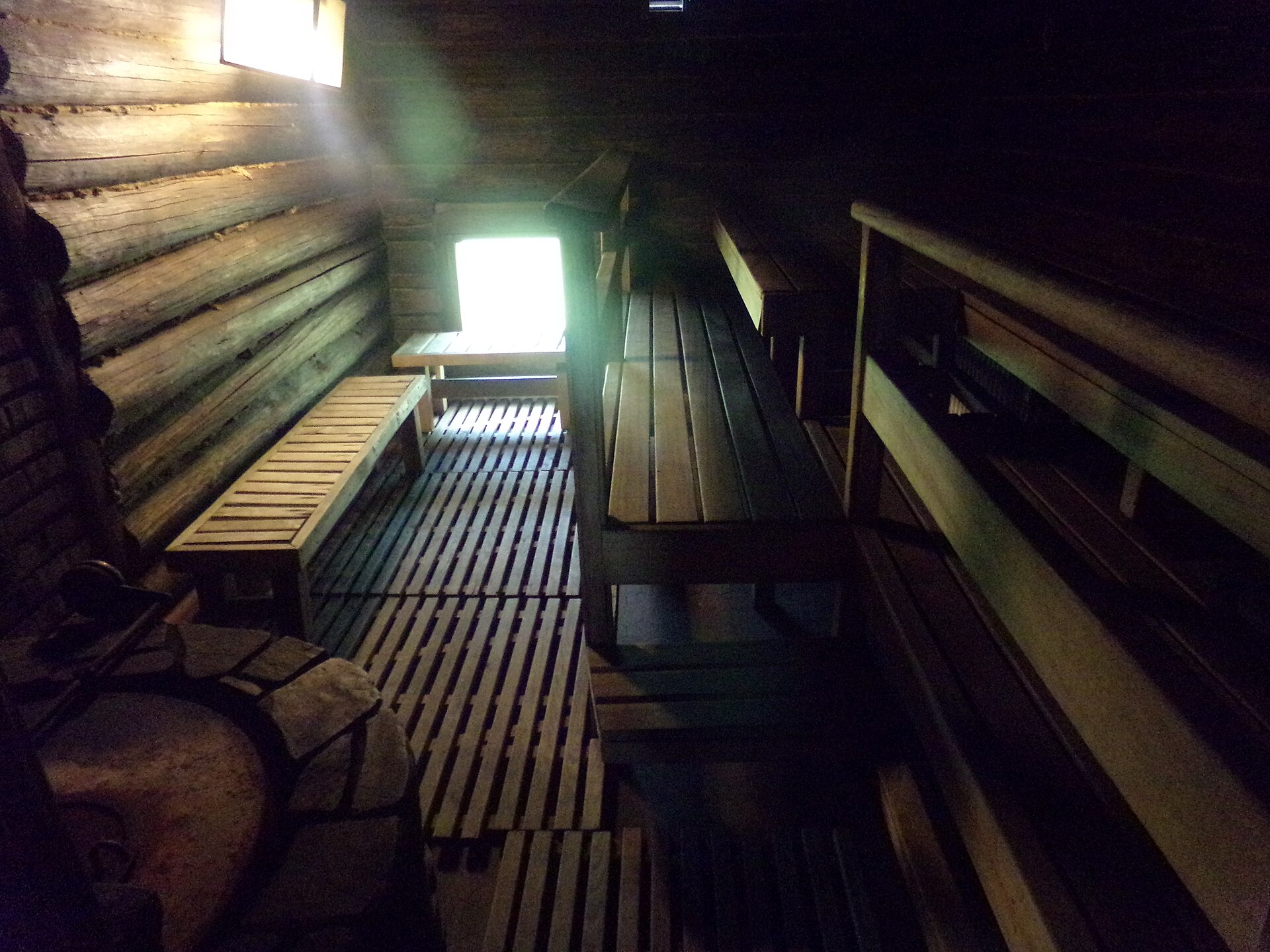 Interior of a traditional Finnish sauna, with wooden benches and a stone stove