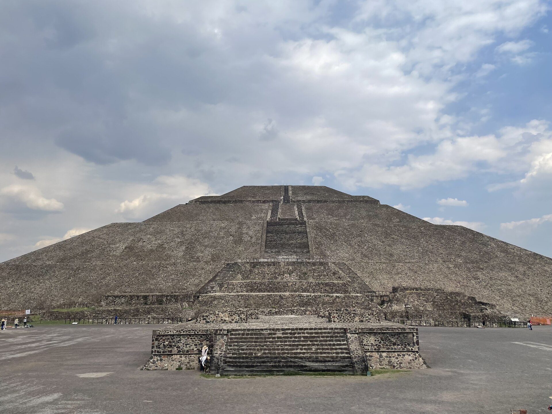 A Pirâmide do Sol de Teotihuacán, com sua grande escadaria central, sob um céu com nuvens